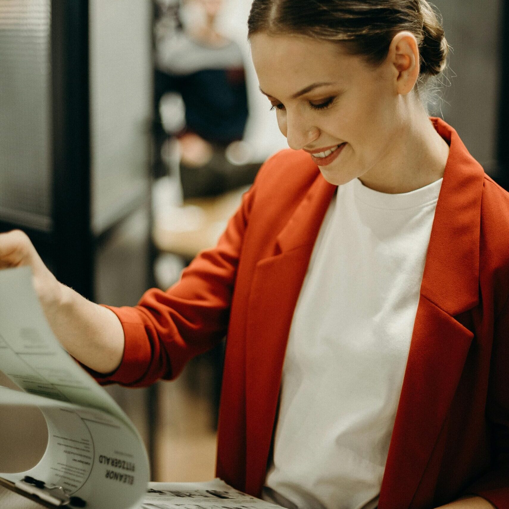 Confident businesswoman reading documents in the office with a smile.